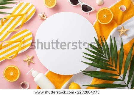 Vacation mode on! Top view flat lay of striped yellow slippers green palm leaves, earrings, bracelet, and sunglasses towel on pastel pink background with empty circle for text or advert