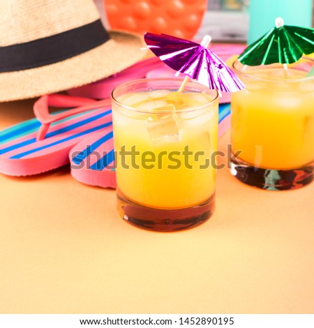 Vacation on the beach concept with colorful summer cocktails and beach accessories - hat, flip flops, sun glasses