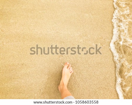 Vacation on ocean beach, female feet on sea sand