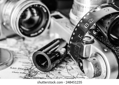 Vacation planning, camera and map of the area on the table. In black and white tones