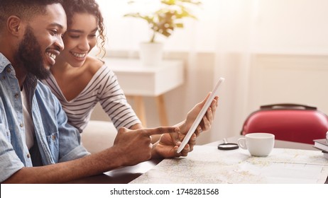 Vacation Plans. Happy African Couple Using Digital Tablet Travel Application Sitting At Desk At Home. Panorama, Copy Space