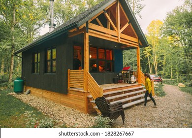 Vacation rental forest lodge countryside cabin by the lake for holidays in the wilderness. Woman entering her house home away from home. - Powered by Shutterstock