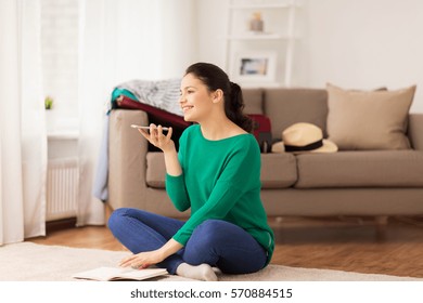 Vacation, Tourism, Travel And People Concept - Happy Young Woman With Smartphone Using Voice Command Recorder At Home