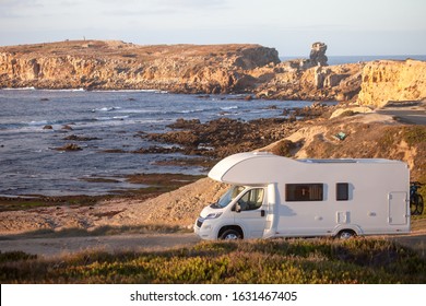 Vacation And Travel In Caravan.Camper Van Motor Home On Seaside Road With A Sunset