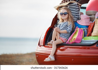 Vacation, Travel - Family Ready For The Travel For Summer Vacation. Suitcases And Car With Sea On Background. Girl With Map In Hands Planning Road Trip. Travel Concept. Traveler.