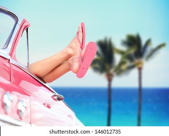 Vacation travel freedom beach concept with cool convertible vintage car and woman feet out of window against tropical see background with palm trees. Girl relaxing enjoying free holidays. - Powered by Shutterstock