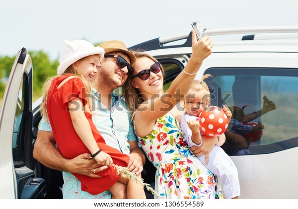 Vacation, Travel - happy family\
ready for the travel for summer vacation. People have fun and take\
pictures on the phone. Take a selfie on the memory of the\
journey