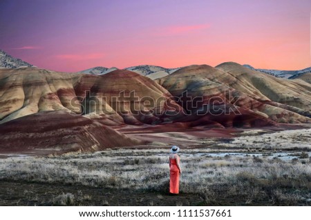 Vacation travel in Oregon. Woman enjoying the view of beautiful Painted Hills at sunset. John Day Fossil Beds National Monument Bend. Or. United States of America