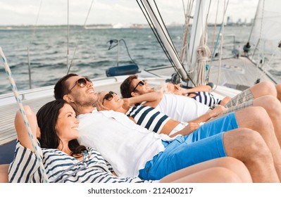 vacation, travel, sea, friendship and people concept - smiling friends lying on yacht deck