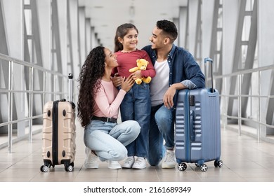 Vacation Trip. Portrait Of Happy Arab Parents And Cute Little Daughter Relaxing At Airport While Waiting For Their Flight, Cheerful Middle Eastern Family Bonding Together, Enjoying Upcoming Travel