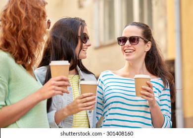 Vacation, Weekend, Takeaway Drinks, Leisure And Friendship Concept - Smiling Happy Young Women Or Teenage Girls Drinking Coffee From Disposable Paper Cups On City Street