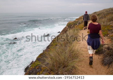 Panorama einer Küstenlandschaft mit einer Frau im Vordergrund