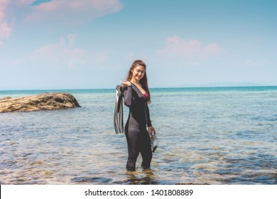 Vacations Of Attractive Asian Woman Wearing Wetsuit And Holding Diving Equipment Fins And Mask Standing On Seashore Smile Feeling So Happiness And Relax Ready To Dive,recreational Diving Concept