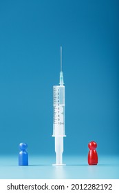 Vaccinate Or Refuse A Syringe With A Vaccine With Two Groups Of People A Red And A Blue Human Model. The Concept Of Distrust And The Dangers Of The Vaccine