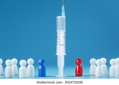 Vaccinate Or Refuse A Syringe With A Vaccine With Two Groups Of People A Red And A Blue Human Model. The Concept Of Distrust And The Dangers Of The Vaccine