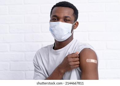 Vaccinated African American Man Showing Arm With Medical Plaster Patch Plaster On Shoulder, Black Female After Getting Vaccine Dose Against Covid. Healthcare Immunization, Coronavirus Vaccination