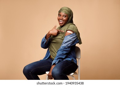 Vaccinated Black Muslim Woman Gesturing Thumbs-Up Approving Vaccination, Beige Background - Powered by Shutterstock