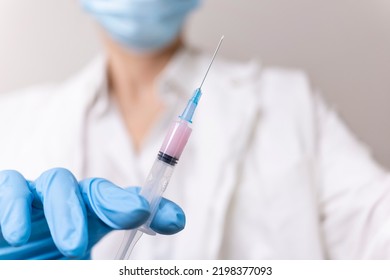 Vaccination against coronavirus. An injection with a vaccine against covid-19. Prevention of influenza disease. The doctor holds a syringe with medicine.  - Shutterstock ID 2198377093