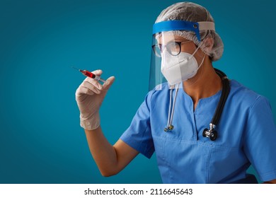 Vaccination Against Covid-19. A Doctor Wearing Face Shield, White N95 Respirator And Medical Gloves Holds A Syringe With A Dose Of COVID-19 Vaccine. Coronavirus Vaccine.