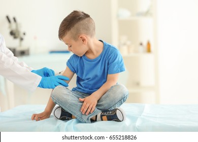 Vaccination concept. Female doctor vaccinating cute little boy in clinic