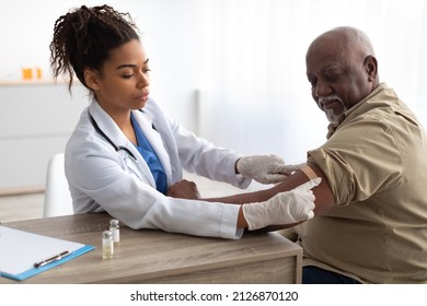 Vaccination Concept. Senior Man Getting Vaccinated Against Flu Or Corona Virus With Antiviral Vaccine, Female Doctor Putting Applying Sticking Adhesive Bandage On Arm After Injection In Hospital - Shutterstock ID 2126870120