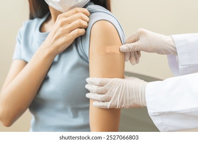 Vaccination coronavirus, hand of doctor apply plaster, bandage after doctor giving vaccine, injection dose on arm patient, immunization disease prevention against flu pandemic influenza, health care. - Powered by Shutterstock