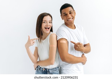 Vaccination, Disease Prevention Concept. Happy Caucasian Girl And Hispanic Guy, Family Couple Received A Vaccine, Medical Plasters On Their Shoulders, Stand On A White Background, Look At Camera,smile