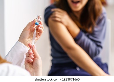 Vaccination healthcare concept - Hands of doctor or nurse hold a syringe and ampule preparing a shot of corona virus covid-19 hpv or flu vaccine for unknown patient - copy space close up