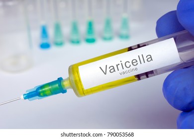 Vaccination healthcare concept. Hands of doctor or nurse in medical gloves with medical syringe ready for injection a shot of Varicella vaccine. close up, selective focus