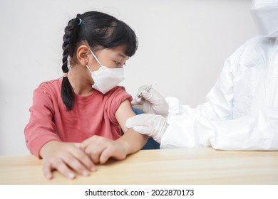 Vaccination, Immunization, Disease Prevention Concept. Kid In Medical Face Mask Getting Covid-19 Or Flu Vaccine At The Hospital.