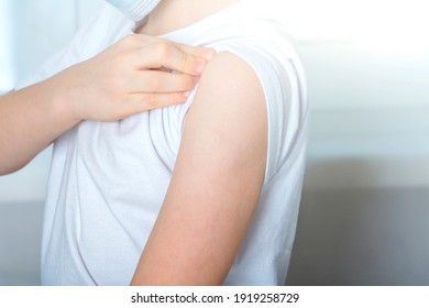 Vaccination And Immunization Of Population Concept. Kid Boy Lifts Sleeve Of T-shirt On Arm To Be Vaccinated. Close Up, Backlight
