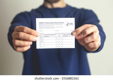 Vaccination record card. Vaccination form during the coronavirus epidemic in the hands of a vaccinated man. New York, USA - February 14 2021