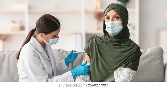 Vaccination. Senior Muslim Lady Patient Getting Vaccinated Against Covid-19, Nurse Injecting Vaccine With Syringe Indoors. Coronavirus Antiviral Immunization Campaign During Epidemic - Powered by Shutterstock