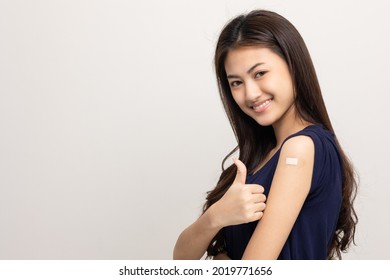 Vaccination. Young Beautiful Asian Woman Getting A Vaccine Protection The Coronavirus. Smiling Happy Female Showing Thumbs Up. On Isolated White Background.
