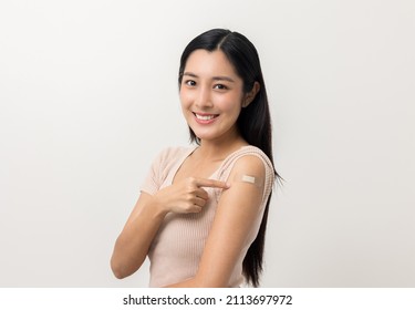 Vaccination. Young Beautiful Asian Woman Getting A Vaccine Protection The Coronavirus. Smiling Happy Female Showing Arm After Receiving Vaccination. On Isolated White Background.