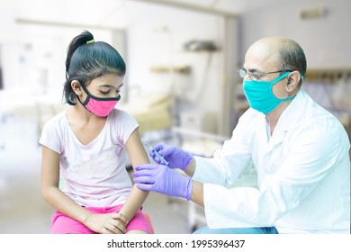 
Vaccine For Children In India, Little Kid Getting Vaccinated By Health Worker  To Protect Against Covid Virus, Child Immunization Program, Doctor Wearing Mask Holding Syringe. Omicron Cases In India
