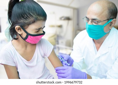 Vaccine For Children In India, Little Kid Getting Vaccinated By Doctor To Protect Against Covid Virus, Child Immunization Program, Healthcare Worker Wearing Mask Holding Syringe. Omicron Cases 