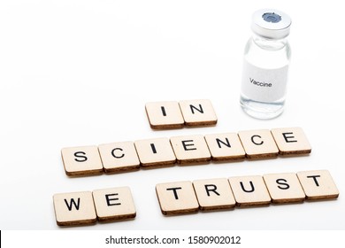 Vaccine Concept Showing A Medical Vial With A Vaccine Label On A White Background Along With A Sign Reading In Science We Trust