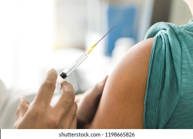 Vaccine Or Flu Shot In Injection Needle. Doctor Working With Patient's Arm. Physician Or Nurse Giving Vaccination And Immunity To Virus, Influenza Or HPV With Syringe. Appointment With Medical Expert.