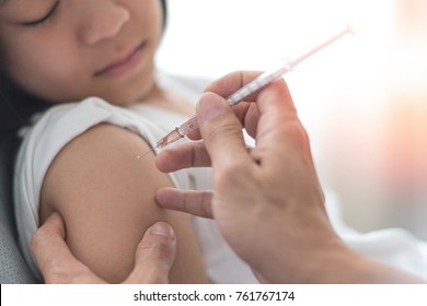 Vaccine HPV healthcare concept. Image of healthy Asia young adult kid girl getting vaccination with doctor pediatrician's hand holding medical syringe in hospital.