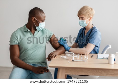 Vaccine for immunization, treatment from coronavirus infection, medical, fight against covid-19. Adult woman nurse in protective mask vaccinates millennial african american patient, with equipment