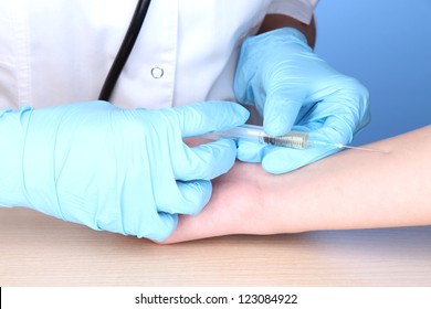 Vaccine Injection In Hand On Blue Background