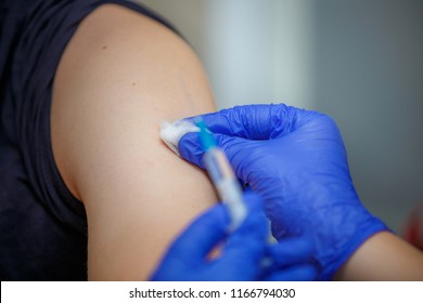 Vaccine injection. Syringe with medicine in the hands of a doctor in blue gloves. Prophylaxis and treatment of infectious and viral diseases. Inoculation against influenza. Vaccination against rabies.