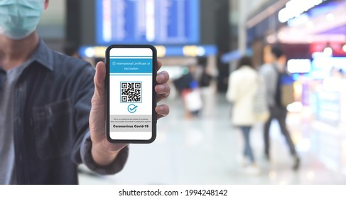 Vaccine passport concept, Male traveler shows health passport of vaccination certification on mobile phone at international airport, to certify that have been vaccinated of coronavirus covid-19 - Powered by Shutterstock