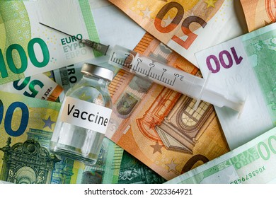 Vaccine Price Or Cost Concept - Glass Vial With Silver Cap On Pile Of Euro Bank Notes, Syringe Near, Closeup Detail From Above