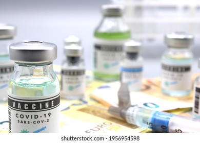 Vaccine Vials Next To A Syringe And On Euro Banknotes