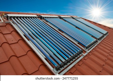 Vakuumsammler- solare Wasserheizung auf rotem Dach des Hauses.