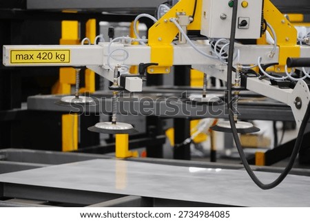 Vacuum lifting beam with multiple suction cups handling large sheet on automated material handling system in warehouse or cutting cell environment