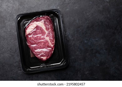 Vacuum packed beef steak. Raw ribeye steak. Top view flat lay with copy space - Powered by Shutterstock