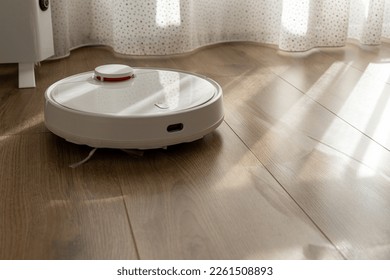 Vacuum Robot cleaning at home. Robot vacuum cleaner in the modern home. Smart cleaning technologyVacuum Robot cleaning at home. Robot vacuum cleaner in the modern home. Smart cleaning technology